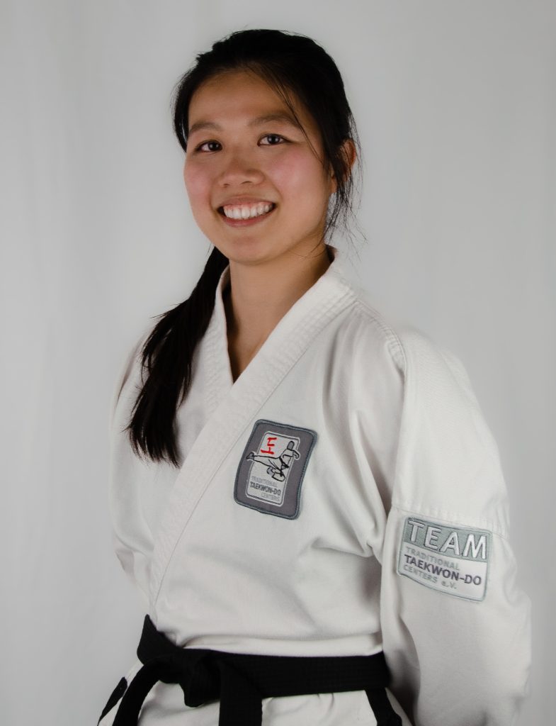 Profilbild von Yun Xia in ihrem weißen Taekwond-Do Anzug mit schwarzem Gürtel.