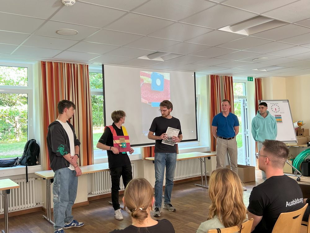 Ausbildungsstart bei Pepperl+Fuchs: 5 junge Männer präsentieren ihre Sensoridee vor den anderen. Sie stehen gemeinsam in einer Reihe.